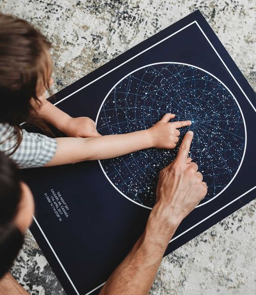 Father and Daughter Pointing at a Star Map