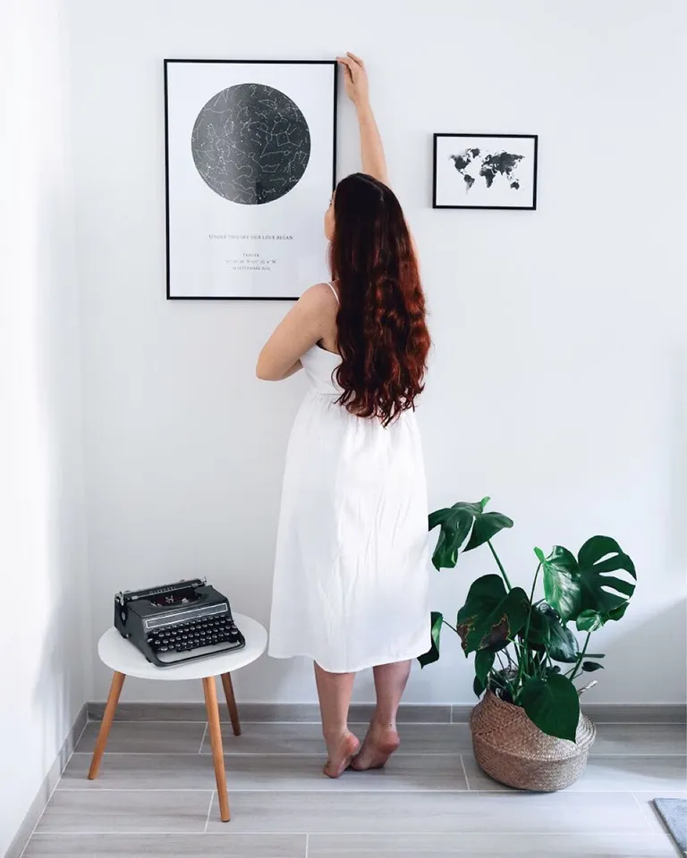 Lady hangs a Star Map on the Wall